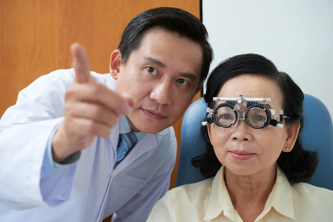 senior-asian-lady-wearing-trial-lens-frame-ophtalmologist-pointing image